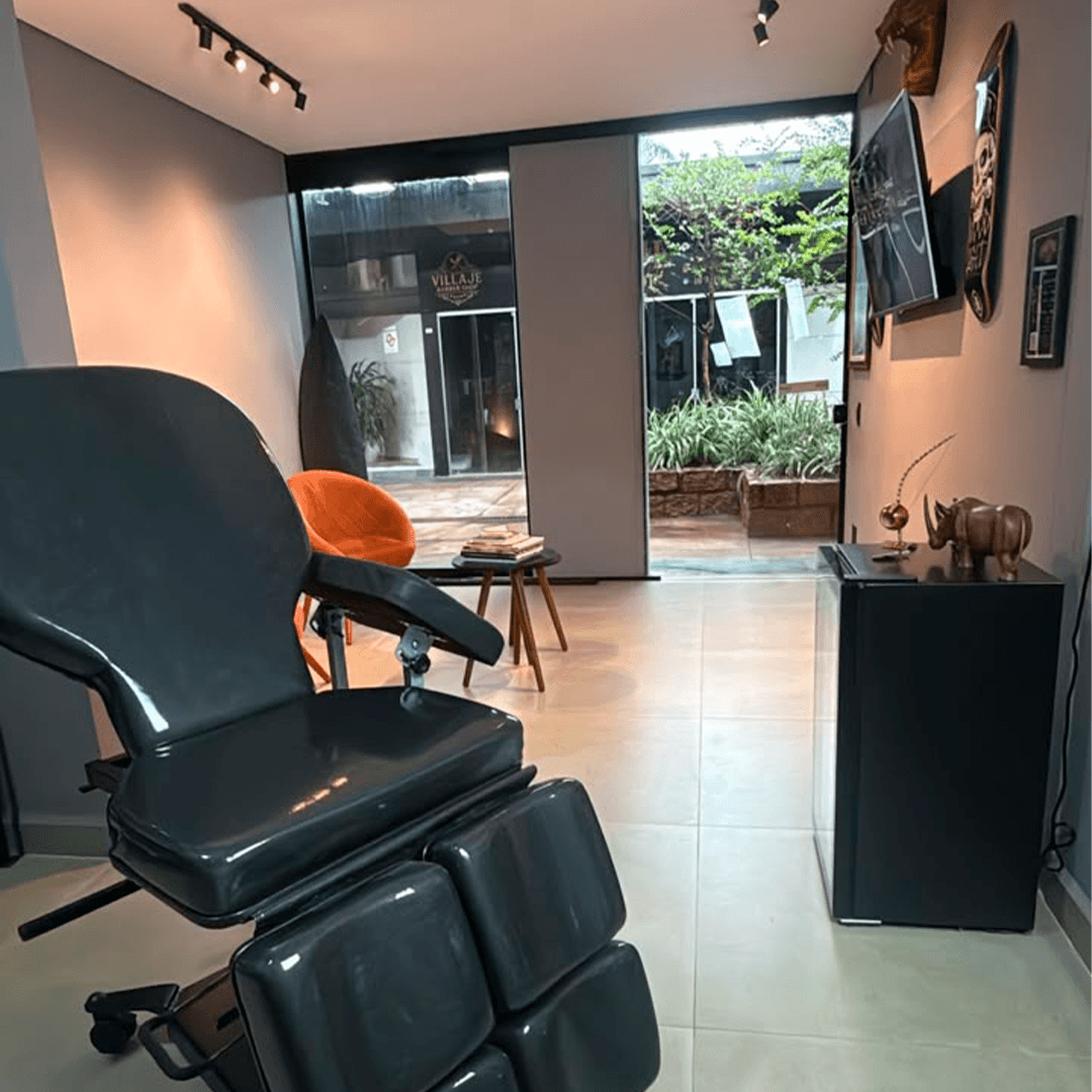 Interior do estúdio Rego Tattoo com cadeira de tatuagem e sala de espera